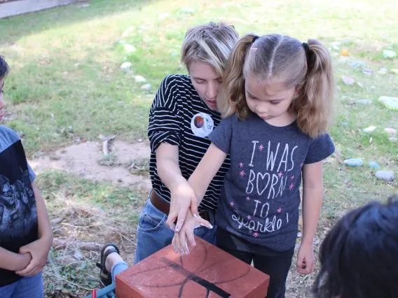 Person giving hands on lesson about biodiversity project to a toddler