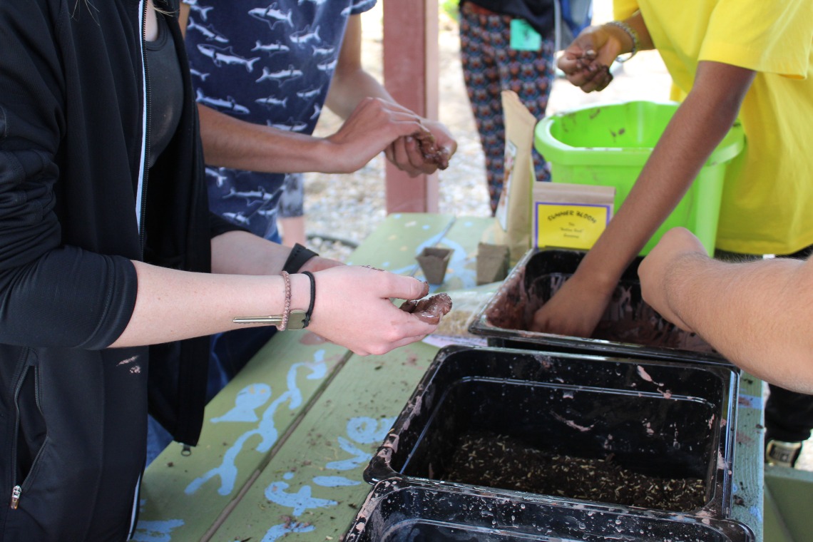 K-12 students making seed balls in their school garden with UArizona student interns as facilitators 