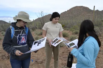 Three interns looking at information on paper